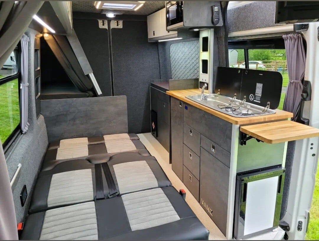 A finished van with seats, a kitchen and top lockers, from the back doors