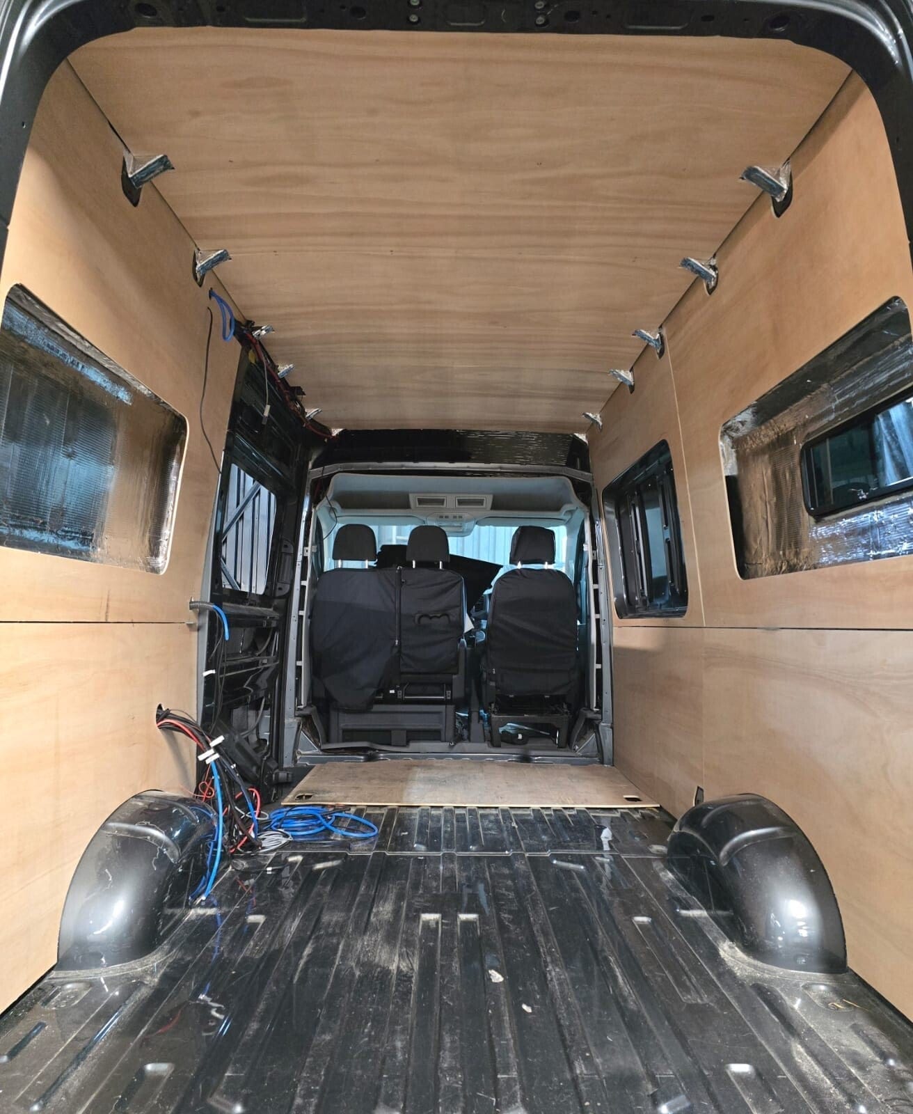 A van boarded on the walls and roof, the wiring in before the floor goes down