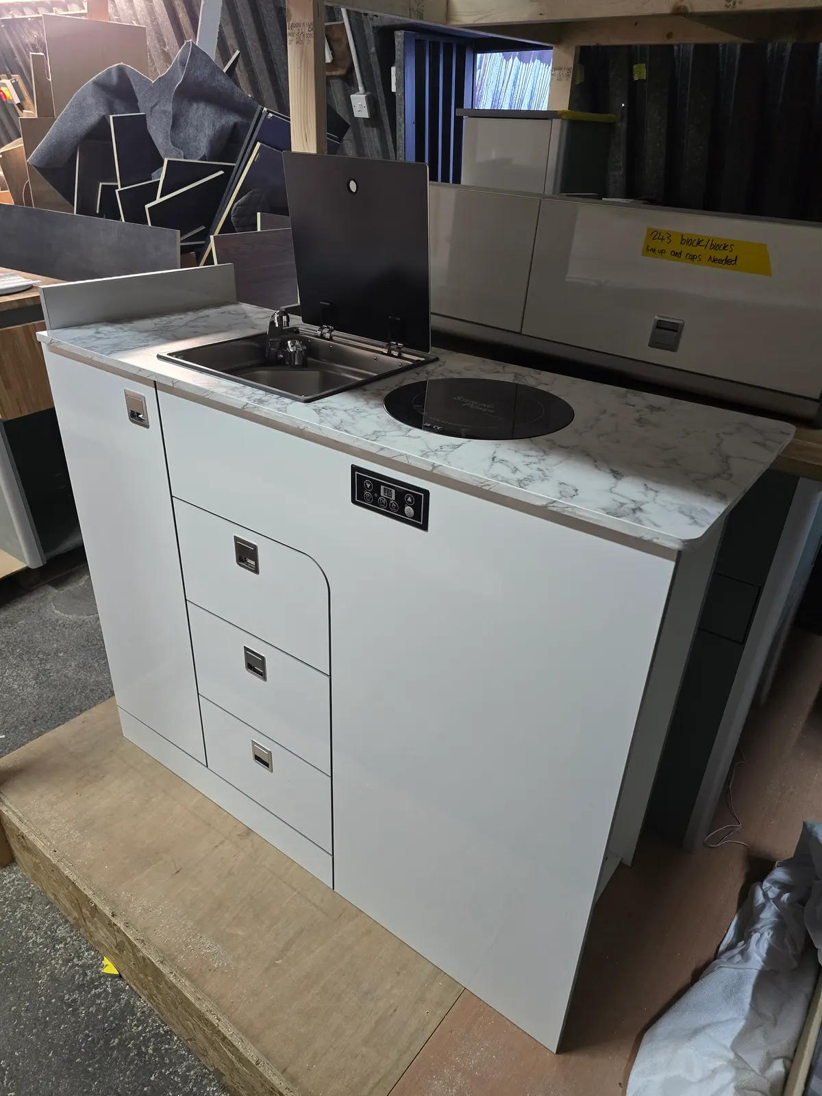 A white gloss kitchen pod with a white marble worktop
